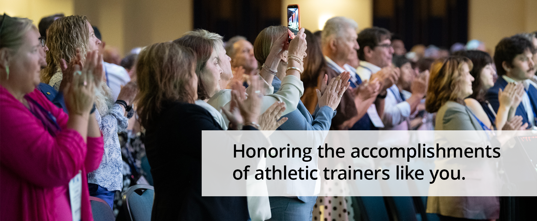 Applauding crowd with text reading "Honoring the accomplishments of athletic trainers like you."