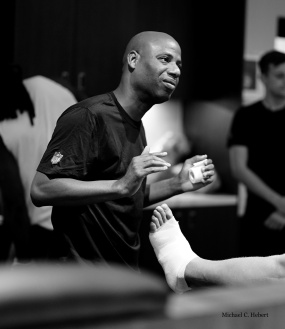 Shone Gipson, a Black athletic trainer, wraps a patient's foot.